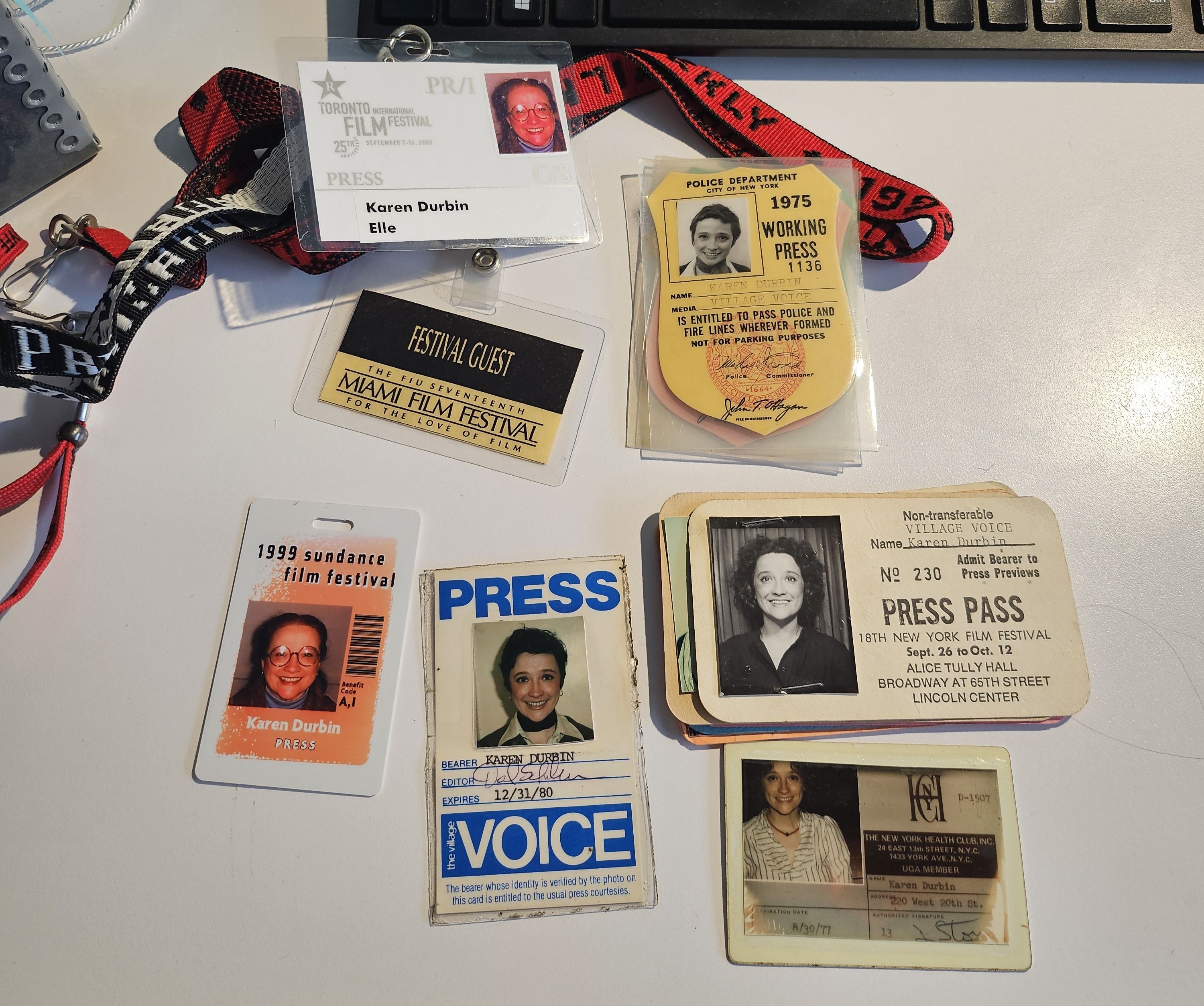 Press passes for Karen Durbin for various publications (the Village Voice, Sundance film festival, and others) displayed on a table