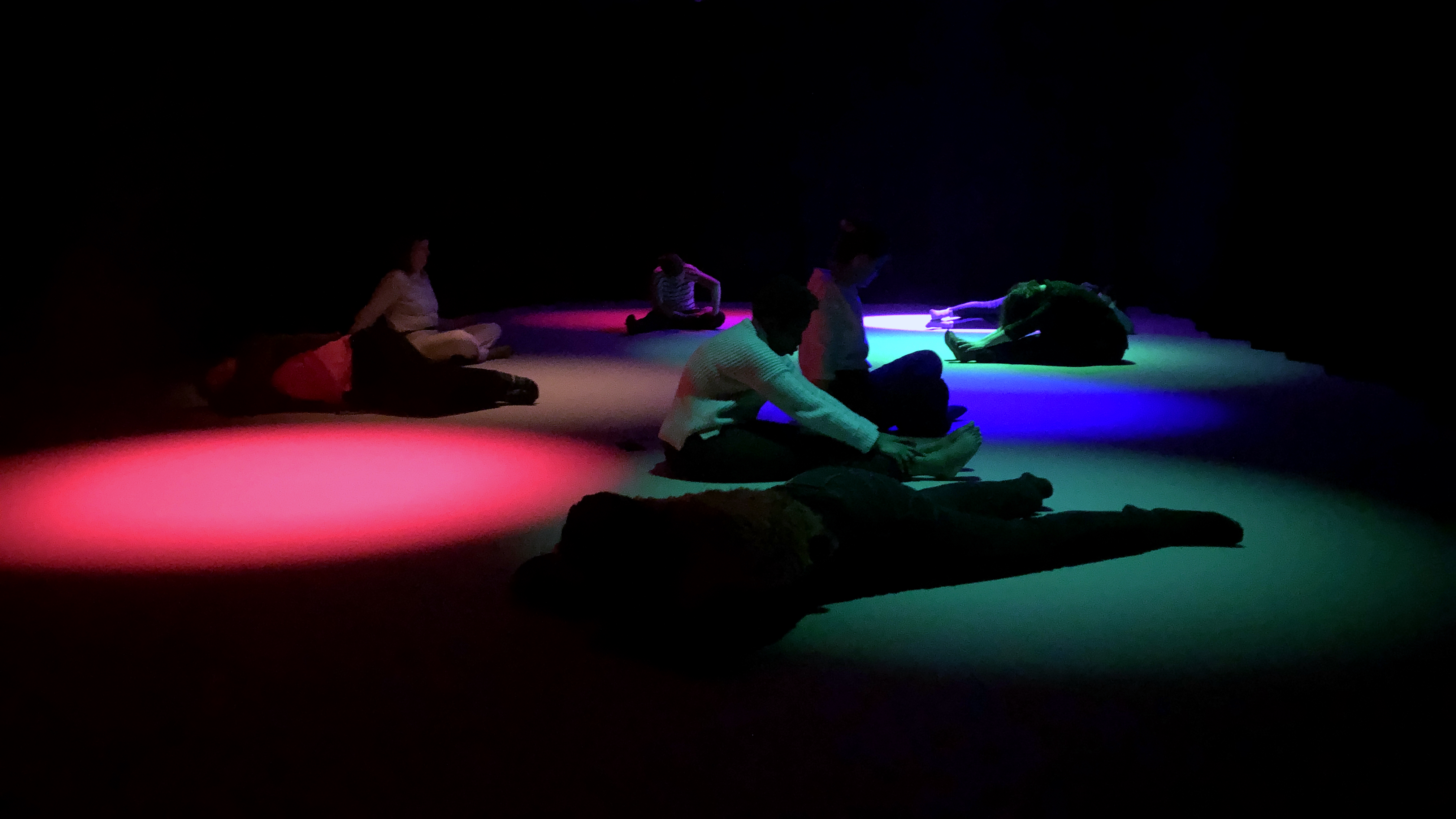 Stillness lab participants in brightly colored red and blue spotlights
