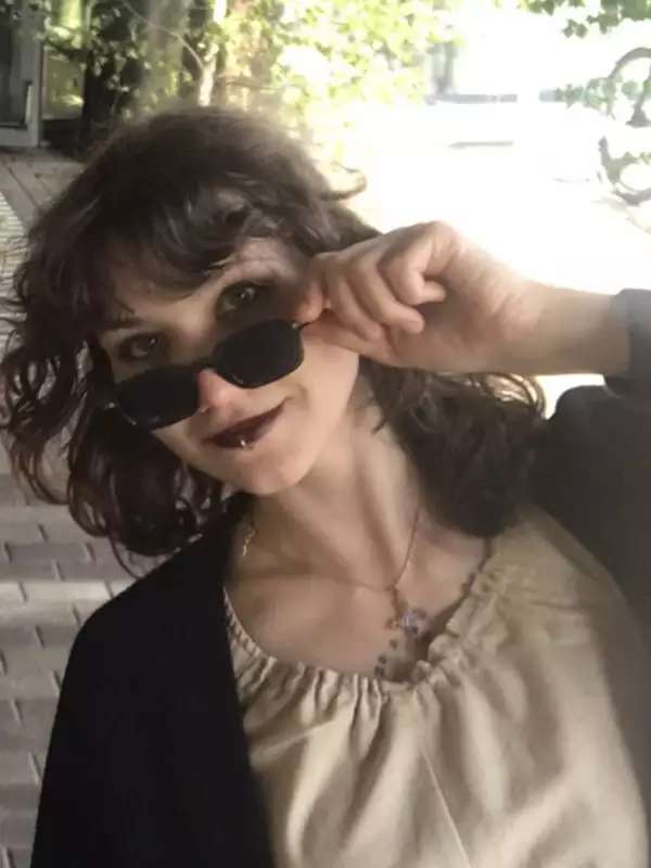 Portrait of Olivija Liepa, shown in sunglasses in a sunny setting
